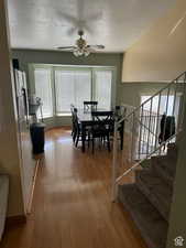 Dining space with ceiling fan, light hardwood / wood-style floors, and a textured ceiling