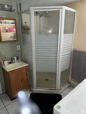 Bathroom with tile patterned flooring, vanity, and an enclosed shower