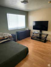 Bedroom featuring hardwood / wood-style floors and a textured ceiling