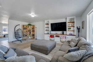 Living room with a textured ceiling and light wood-type flooring