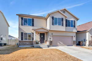 View of front of house featuring a garage and central AC