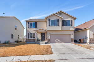 View of front of home with a garage and central AC unit