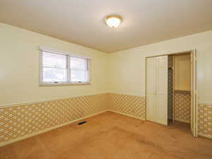 Unfurnished bedroom with a closet and light carpet