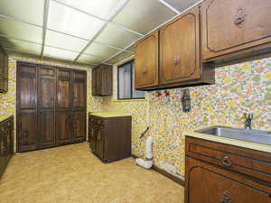 Kitchen with a drop ceiling, sink, and dark brown cabinets