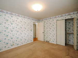 Unfurnished bedroom with carpet floors and a closet