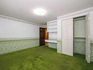 Unfurnished bedroom featuring dark carpet