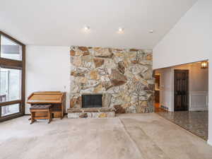 Living room featuring a stone fireplace and carpet