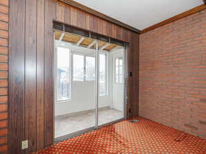 Interior space with a textured ceiling and brick wall