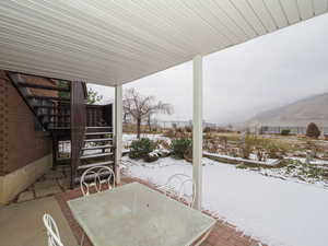 Snow covered patio with a mountain view