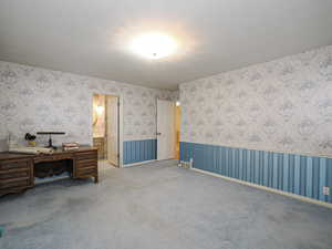 Carpeted bedroom featuring ensuite bath