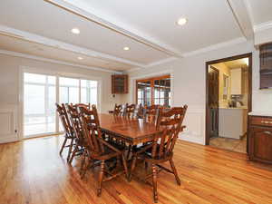 Dining space featuring beam ceiling, crown molding, and light wood-type flooring