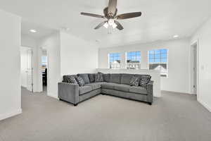 Living room featuring ceiling fan and light carpet