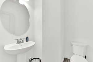 Bathroom featuring wood-type flooring and toilet