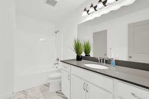 Full bathroom featuring vanity, shower / bathtub combination, and toilet