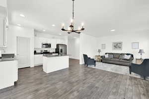 Kitchen featuring pendant lighting, sink, dark wood-type flooring, stainless steel appliances, and white cabinets