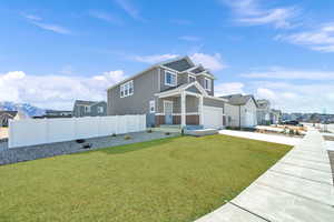 View of front of home featuring a garage, a mountain view, and a front yard