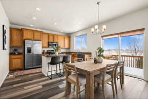 Dining space featuring dark hardwood / wood-style flooring, sink, and an inviting chandelier