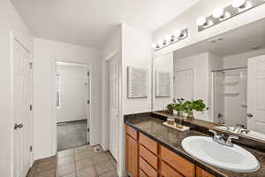 Bathroom featuring tile patterned floors, vanity, washtub / shower combination, and a textured ceiling