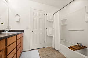 Bathroom with tile patterned floors, shower / tub combo, and vanity