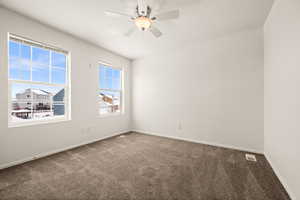 Carpeted spare room featuring ceiling fan