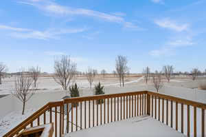 Snow covered deck with a rural view