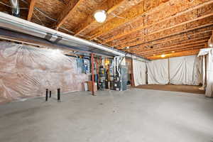 Basement featuring heating unit and electric panel