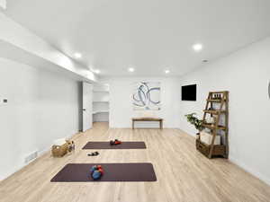 Workout room with light wood-type flooring