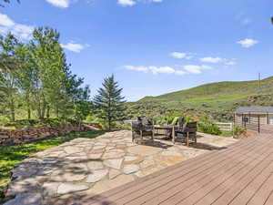 Wooden deck featuring a mountain view and a patio