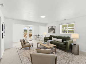 Living room with light carpet, a wealth of natural light, and french doors