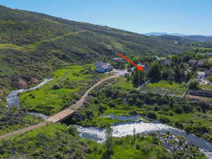 Birds eye view of property with a water and mountain view