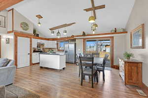 Kitchen featuring white cabinetry, appliances with stainless steel finishes, wood-type flooring, and hanging light fixtures