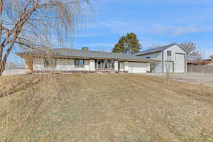 View of front of house featuring a garage, a porch, and a front lawn