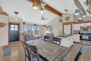 Dining room featuring beamed ceiling, ceiling fan, high vaulted ceiling, and dark wood-type flooring