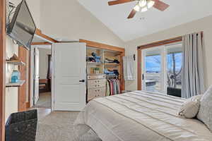 Carpeted bedroom with ceiling fan, access to exterior, vaulted ceiling, and a closet