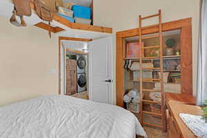 Bedroom with stacked washer and dryer