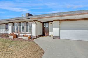 View of front facade featuring a garage and a front lawn