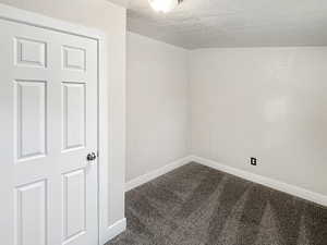 Carpeted spare room featuring a textured ceiling