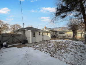 Snow covered rear of property with a mountain view and central AC