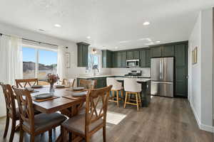 Dining space featuring dark wood-type flooring, sink, and a textured ceiling