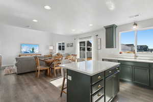 Kitchen featuring dark hardwood / wood-style floors, a breakfast bar, sink, a center island, and a textured ceiling