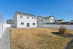 Back of house with a lawn and a patio