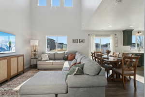 Living room with dark hardwood / wood-style floors, sink, a textured ceiling, and a high ceiling