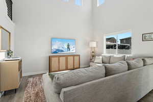 Living room with hardwood / wood-style floors and a towering ceiling