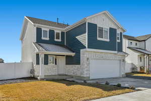 View of front of home with a garage and a front lawn