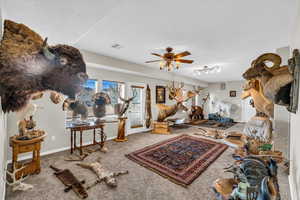 Carpeted living room featuring ceiling fan