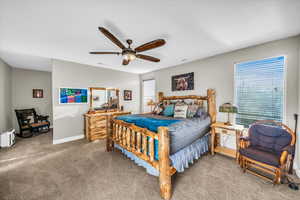 Carpeted bedroom featuring ceiling fan