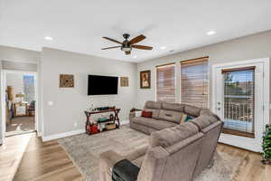 Living room with ceiling fan and light hardwood / wood-style flooring