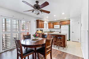 Dining space with ornamental molding, ceiling fan, and light hardwood / wood-style floors