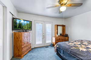 Bedroom featuring light carpet, access to exterior, ceiling fan, and french doors