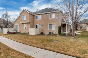 Rear view of property with a yard and central AC unit